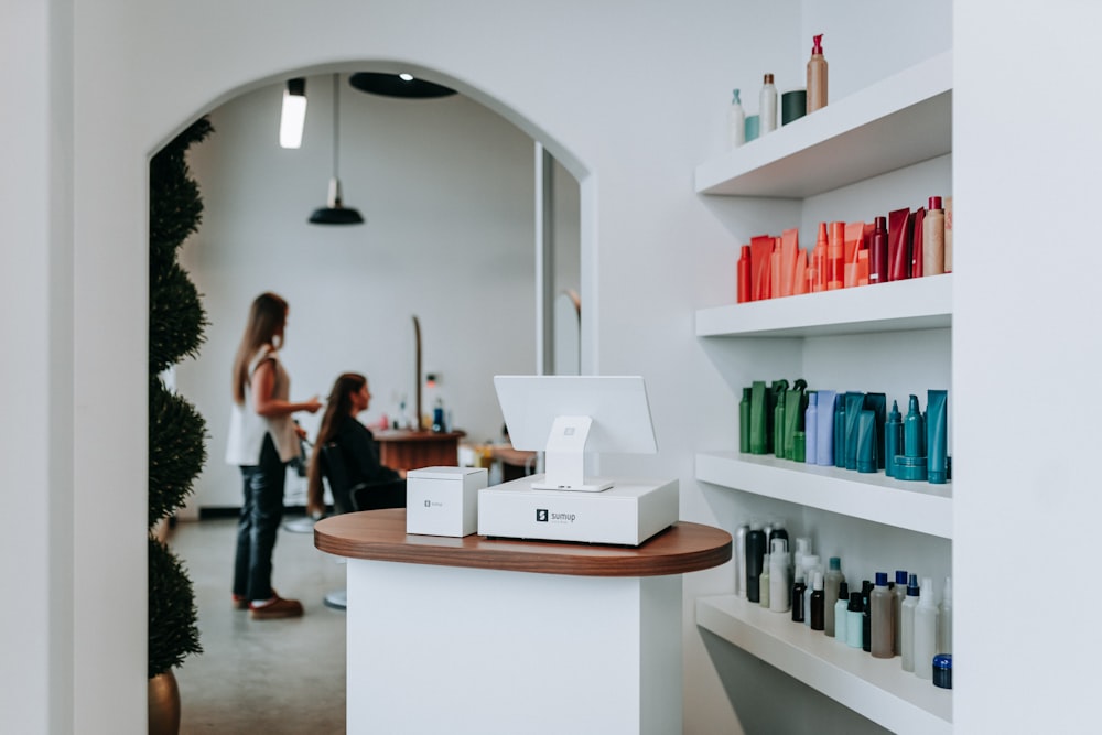 The salon floor with product shelves and clients in the chairs