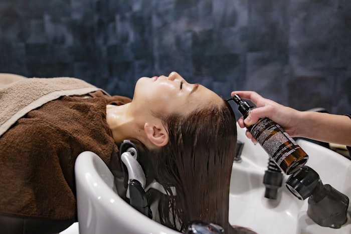 A client reclining at the wash basin during a hair spa