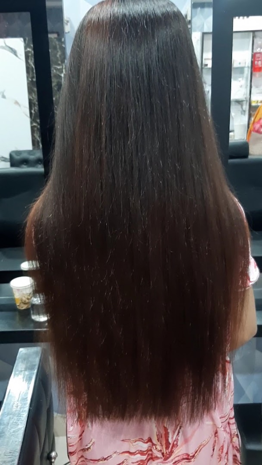 Long dark hair with a high-shine silk finish falling past the shoulders after a gloss treatment.
