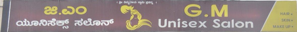 The G.M Unisex Salon signboard on 12th Cross Road: gold lettering on deep wine, the flowing-hair mark, the Kannada name, and a gold panel reading HAIR · SKIN · MAKE UP.