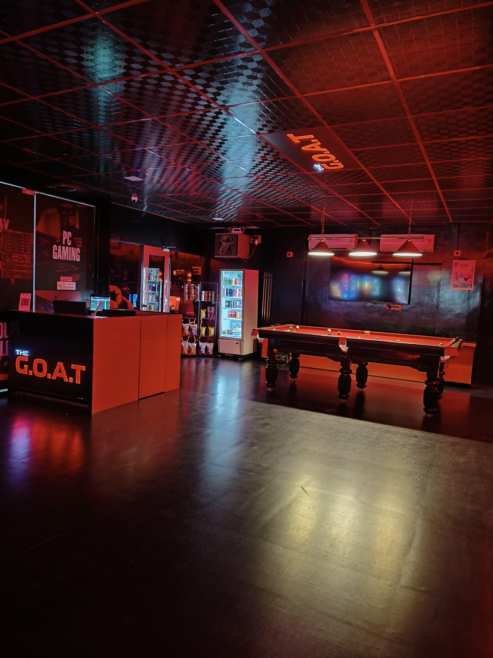 The G.O.A.T Gaming Cafe lobby — reception sign, pool table and PC gaming floor