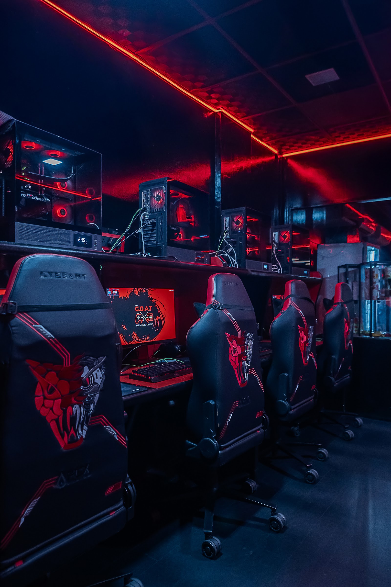 Rows of pro gaming battlestations glowing red inside The G.O.A.T Gaming Cafe, Jayanagar