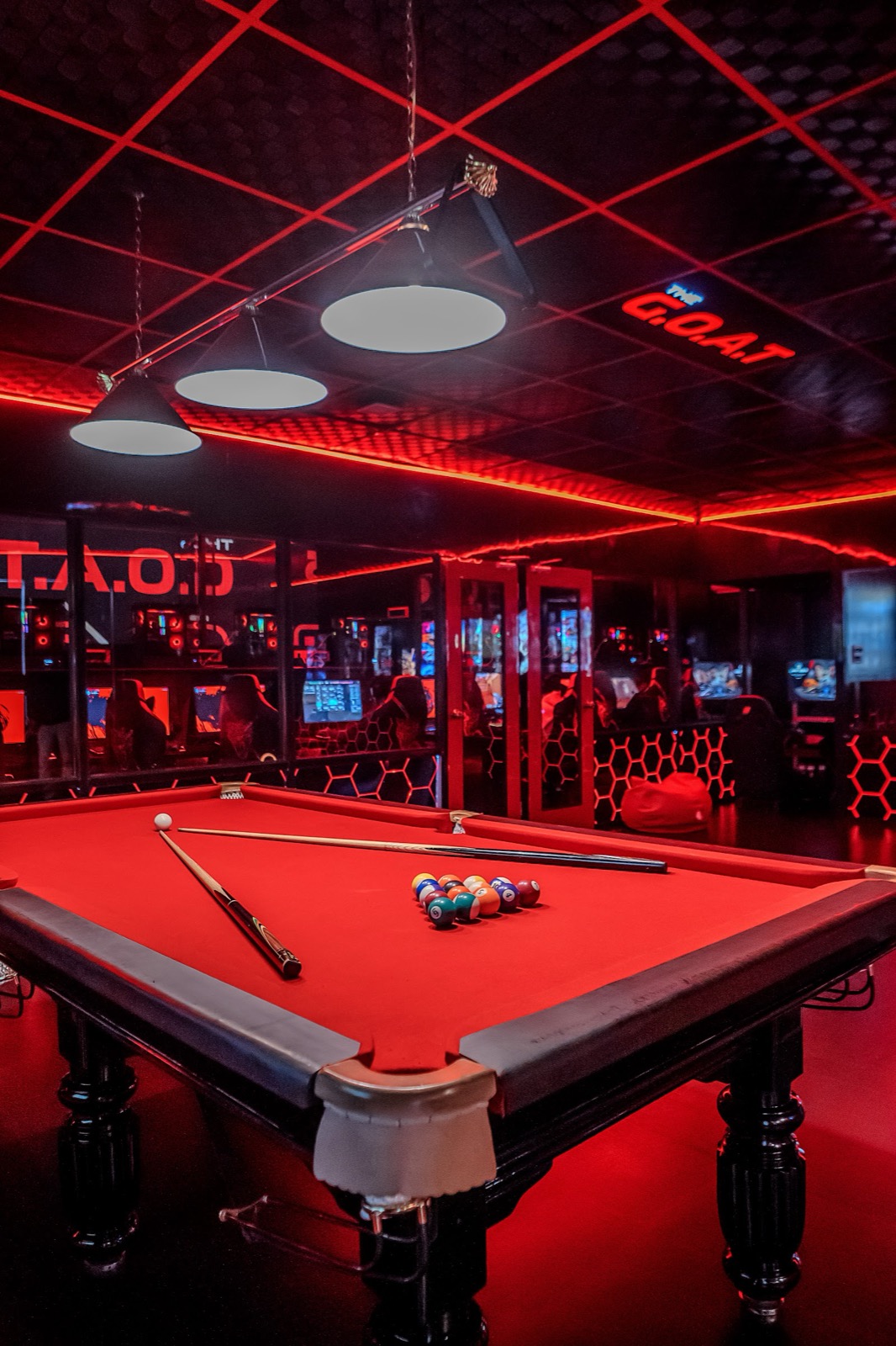 Red-felt pool table under neon at the Jayanagar den