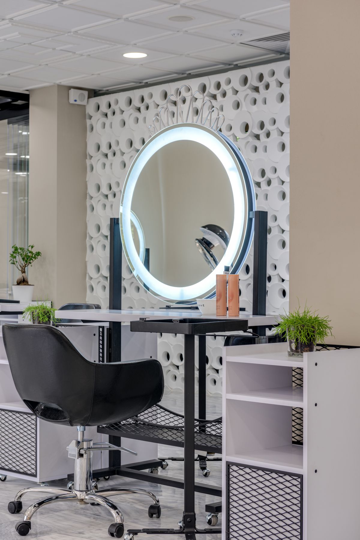 A styling station lit by a large LED-ringed oval mirror.