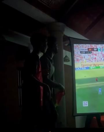 Fans watching a live football match on the big projector screen at playmode