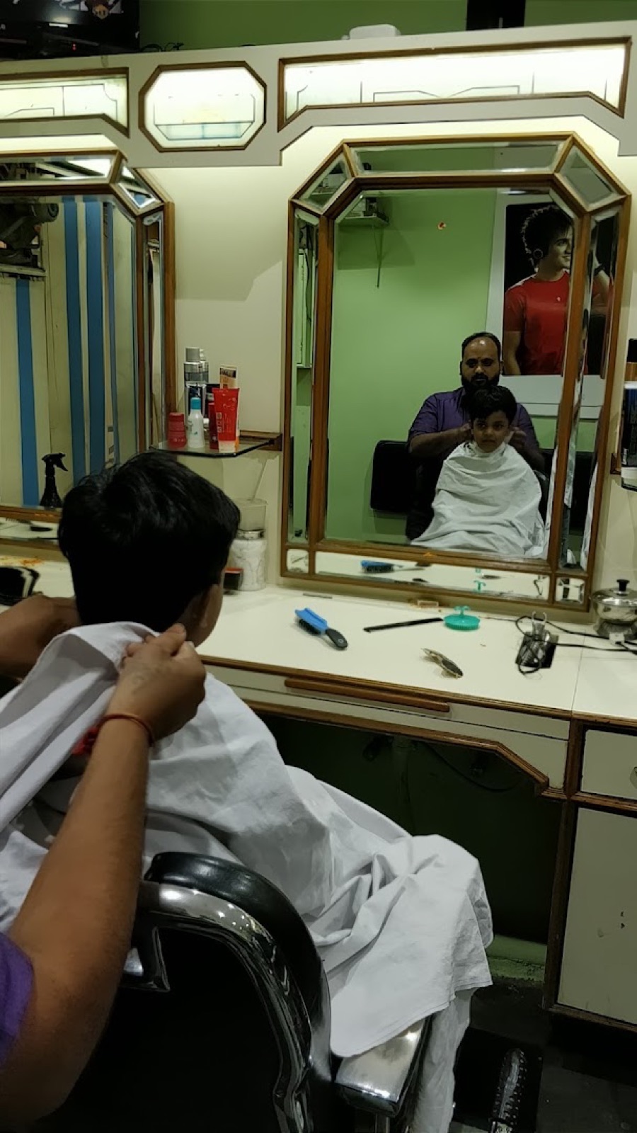 A gents' haircut in progress at a classic mirror station