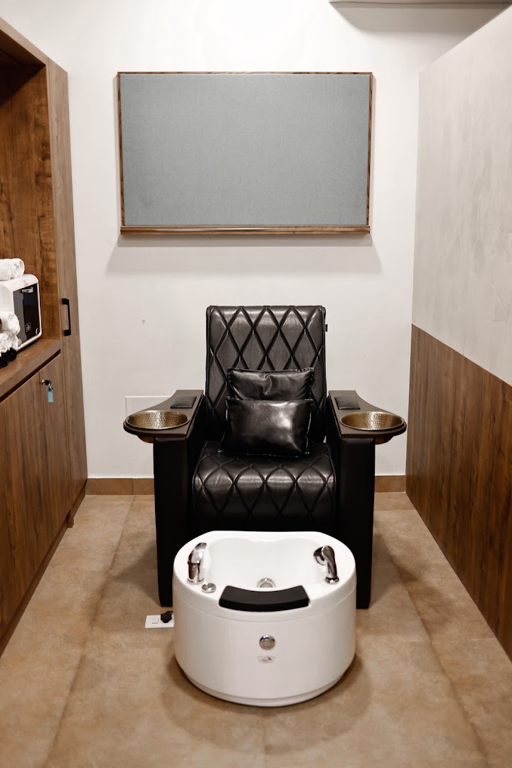The pedicure lounge — quilted recliners with brass bowls and a white foot spa