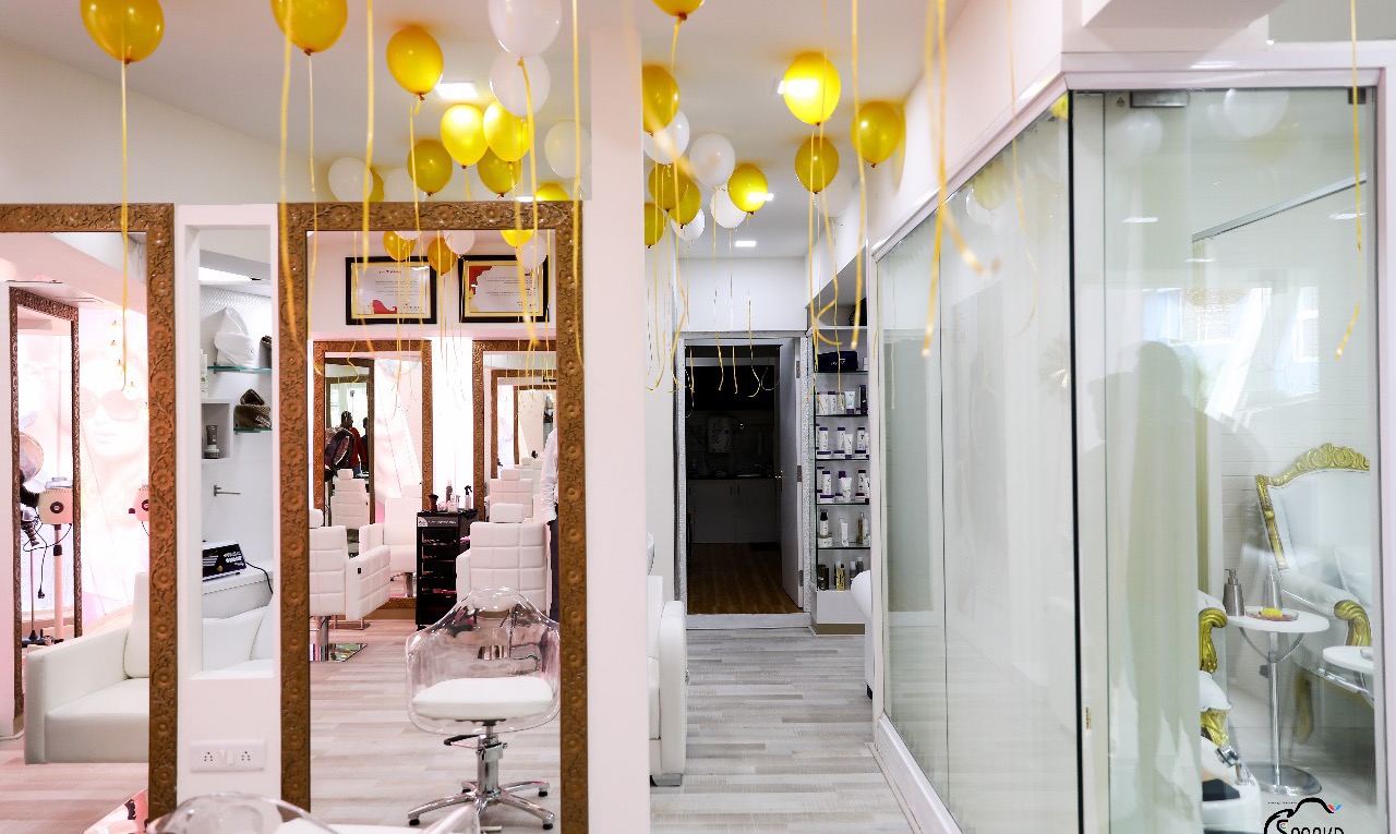The ladies' styling floor at STUDIO@11: white stations, gold-framed mirrors and soft festive lighting.